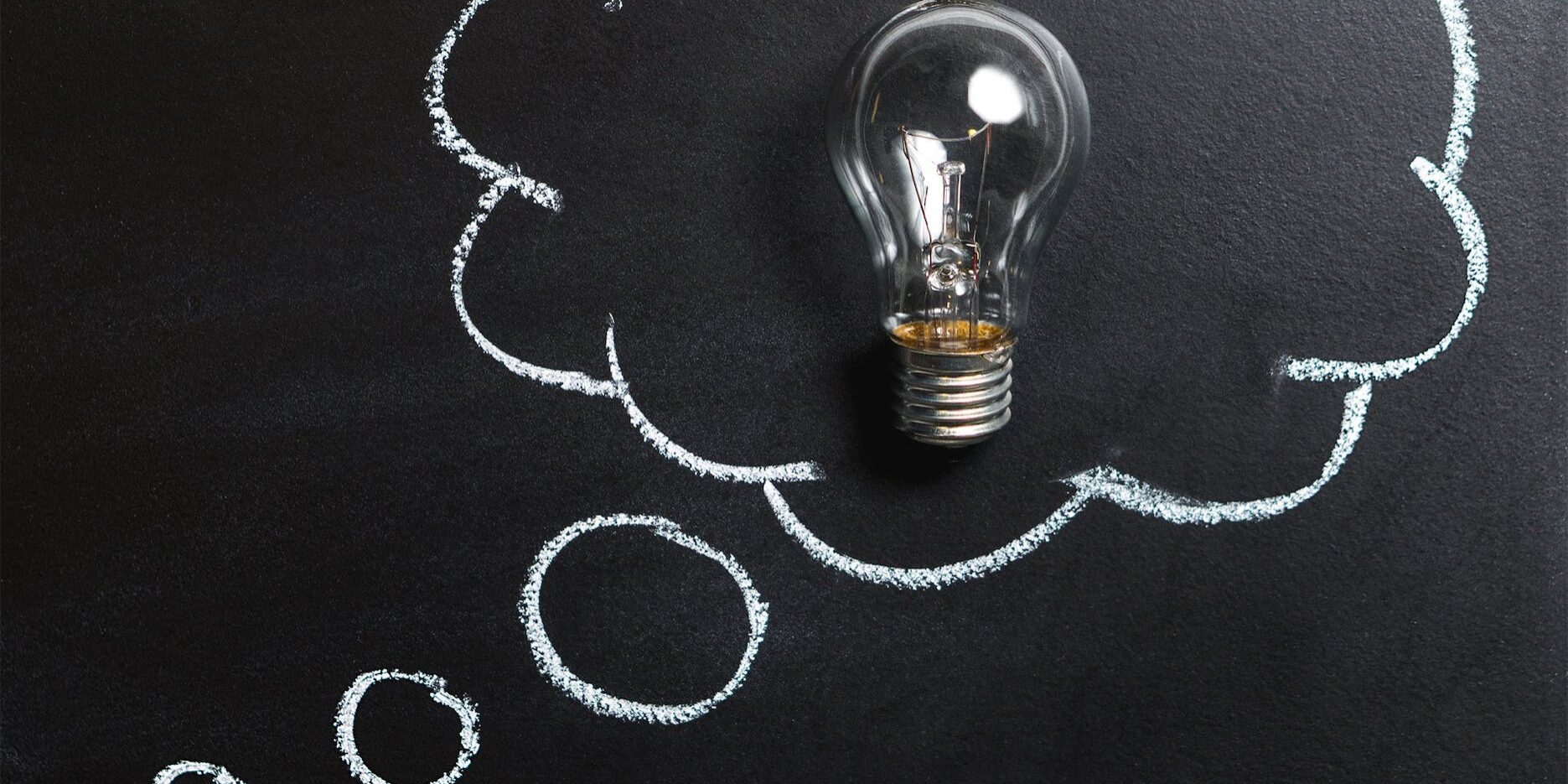 clear light bulb placed on chalkboard