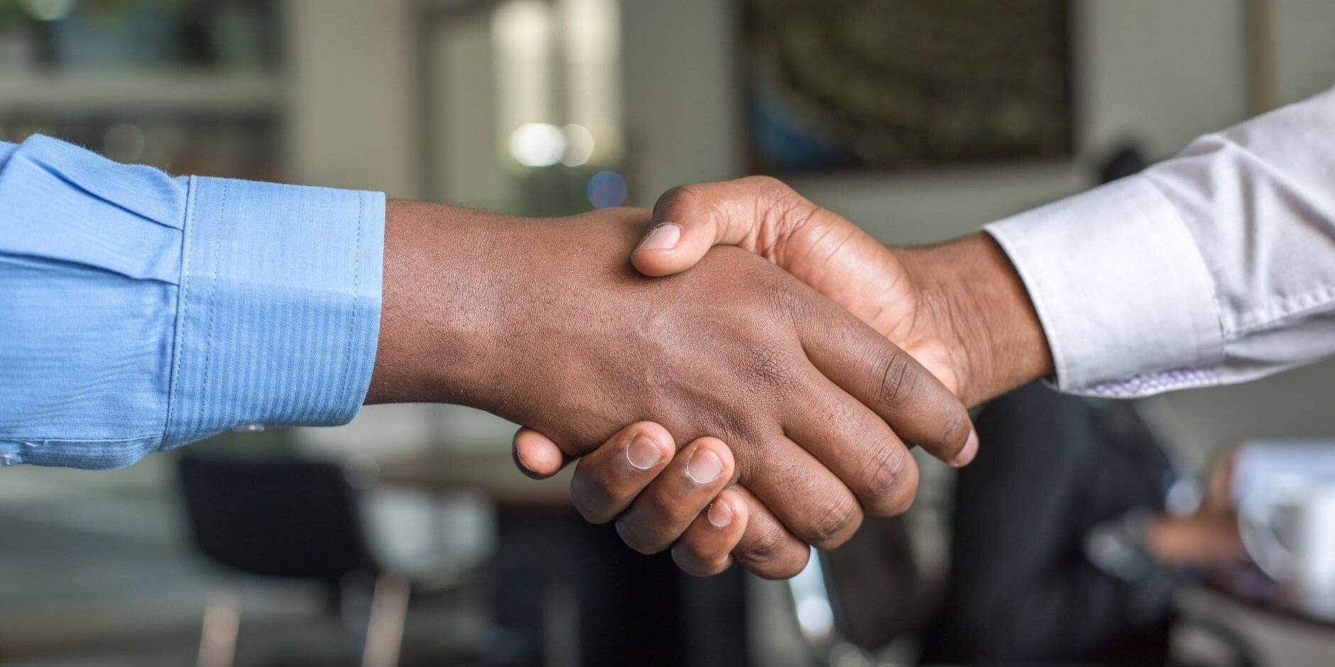two person in long sleeved shirt shakehand