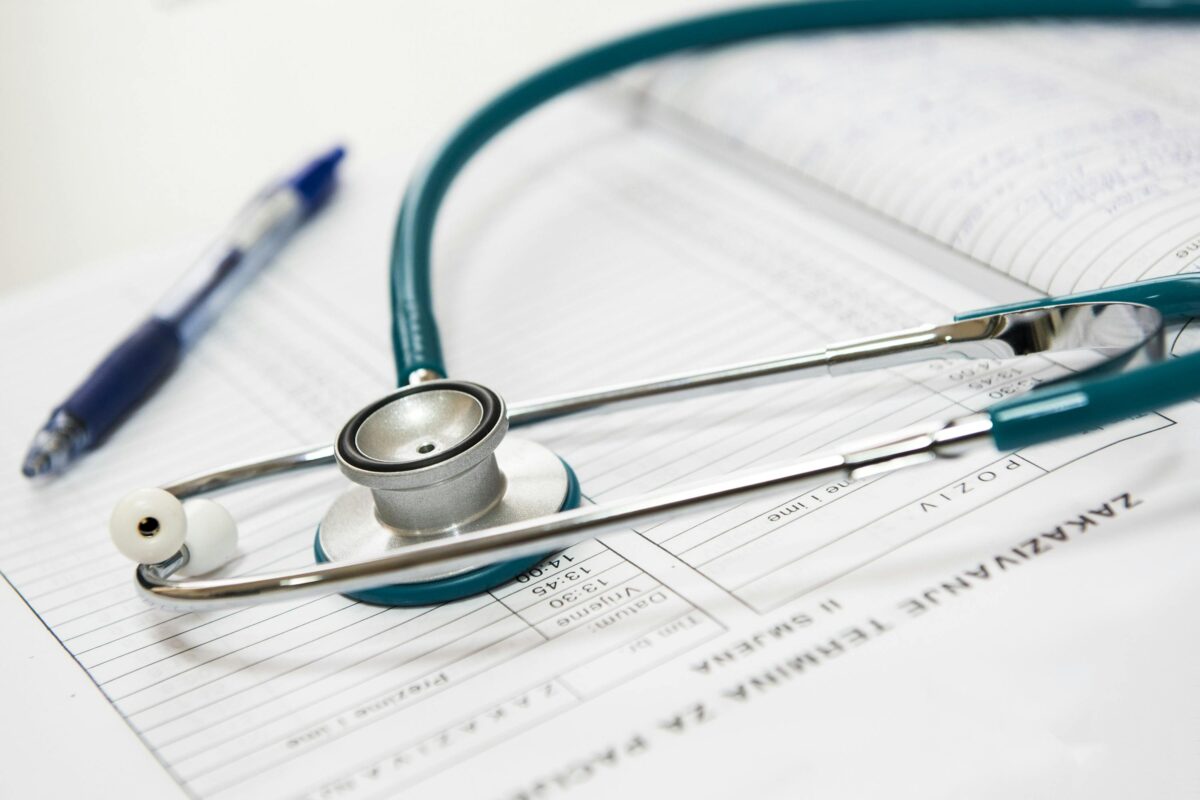 Image of a stethoscope and a pen on a notepad.